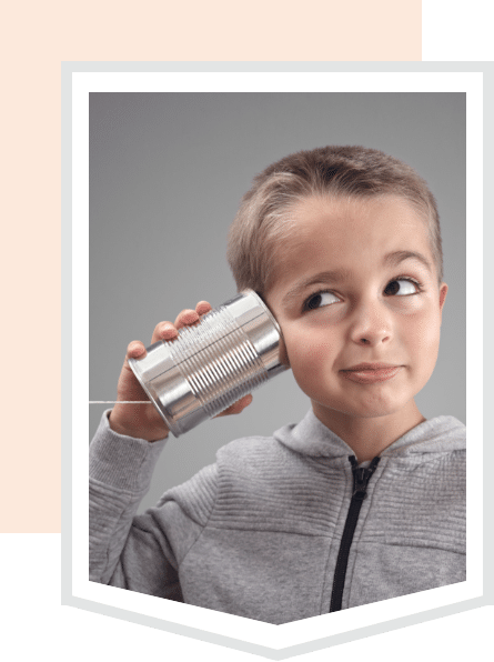Ein Junge hört mit einer Dose, die als Telefon verwendet wird, auf ein Gespräch.